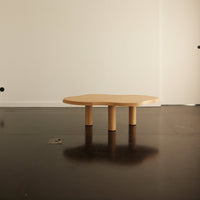 Natural wood coffee table with a unique octagonal shape and smooth, light beige finish. Modern minimalist design.