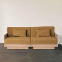"Two-seater sofa in warm mustard fabric with solid wood base, featuring minimalist design and plush cushions."