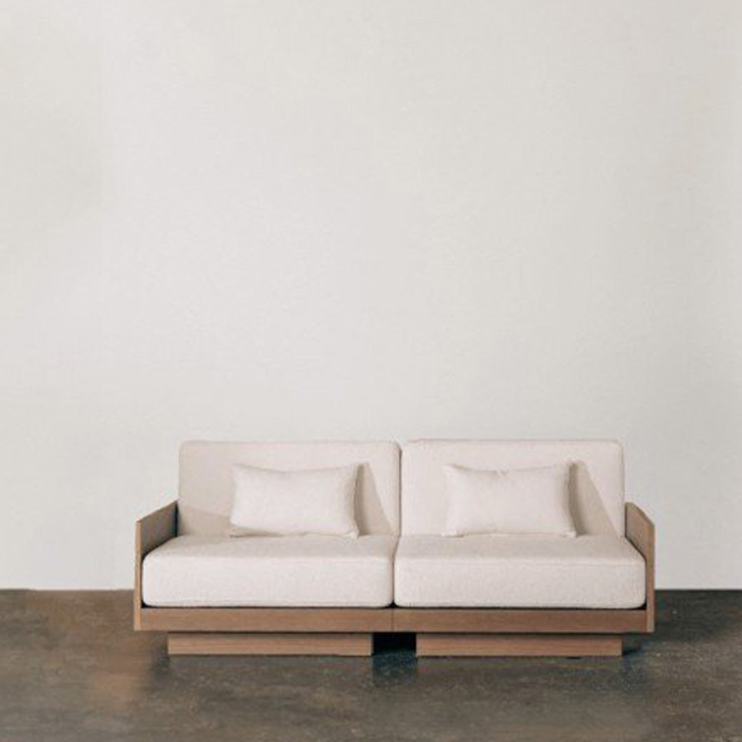Light beige sofa with smooth fabric, featuring a minimalist design and wooden base, ideal for modern interiors.