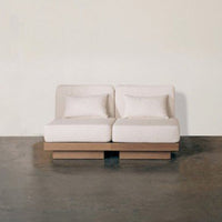 Light beige modern sofa with clean lines and two plush cushions against a neutral background.