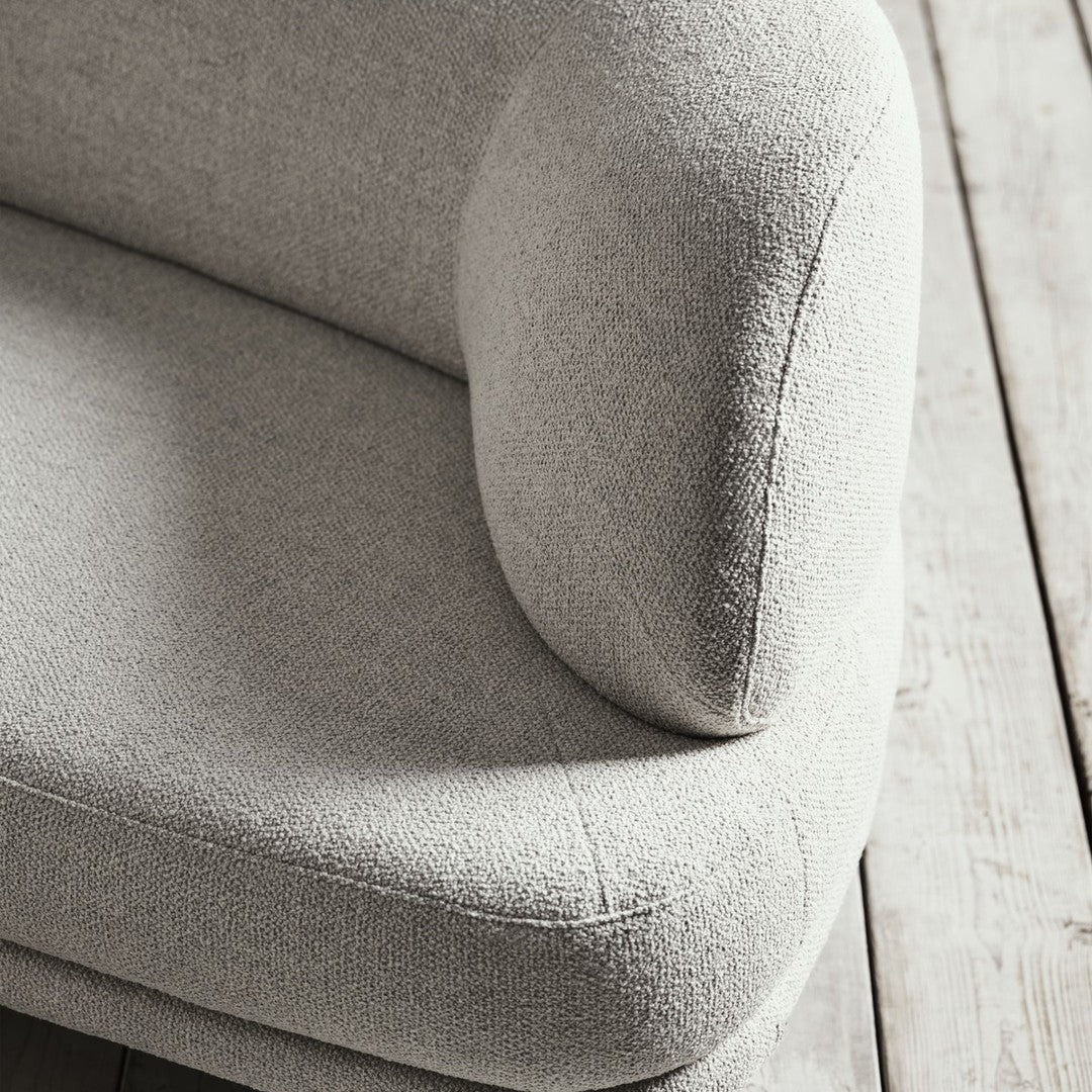 Light gray textured upholstery with a soft, modern curve, set against a natural wood background.