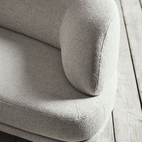 Soft gray upholstery with a textured finish, featuring a smooth, rounded armrest and minimalist design.