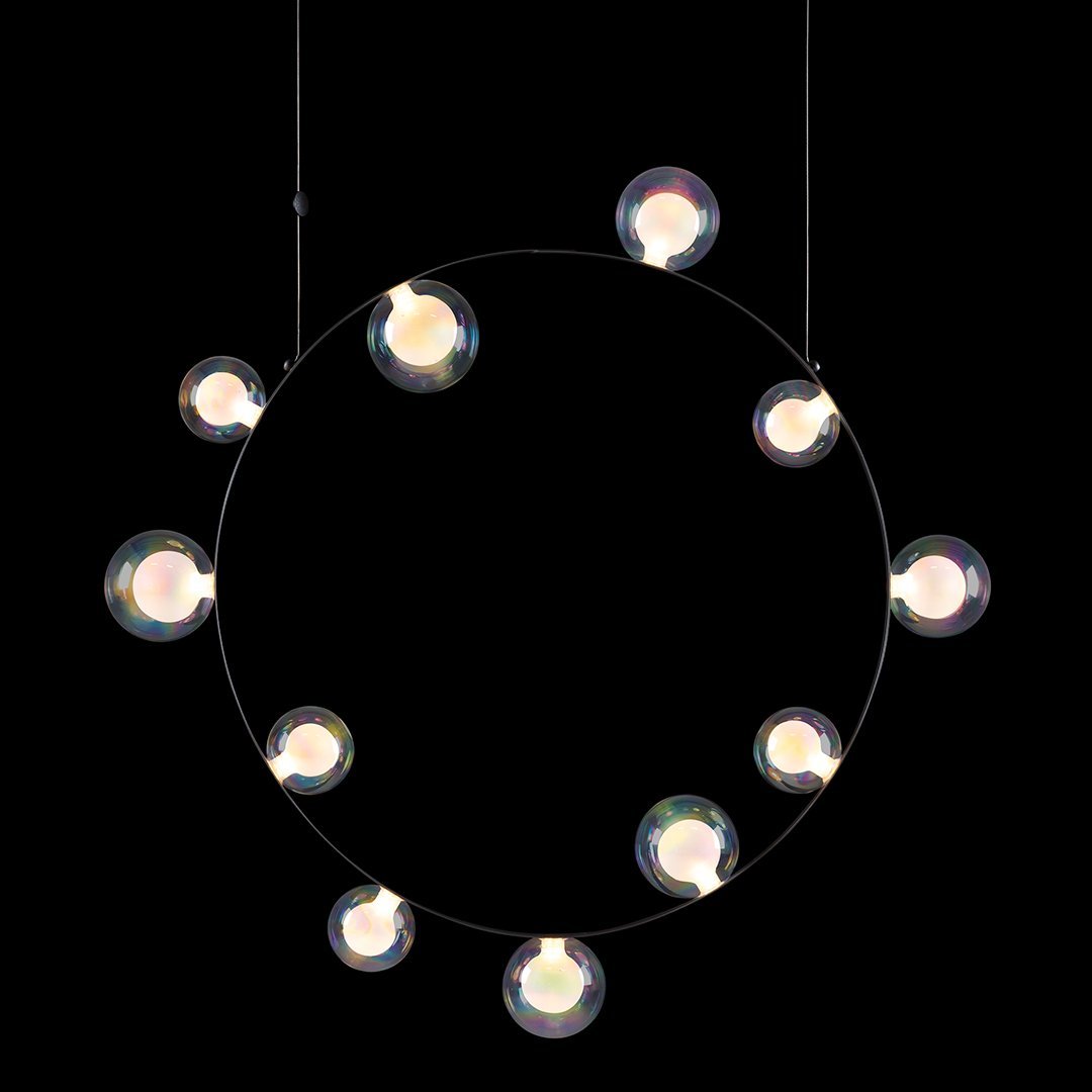 Circular chandelier with clear globes on a black background, showcasing a modern minimalist design.