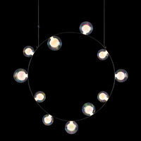 Circular chandelier with clear globes on a black background, showcasing a modern minimalist design.