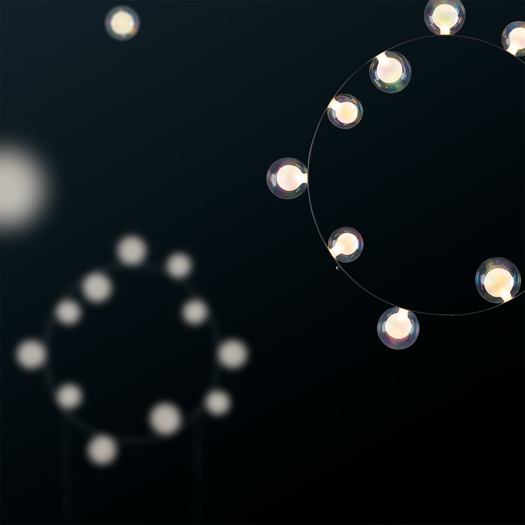Elegant circular light pattern against a dark background, featuring glowing orbs in a modern design.
