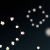 Delicate circles with glowing white lights against a dark background create a subtle, modern pattern.
