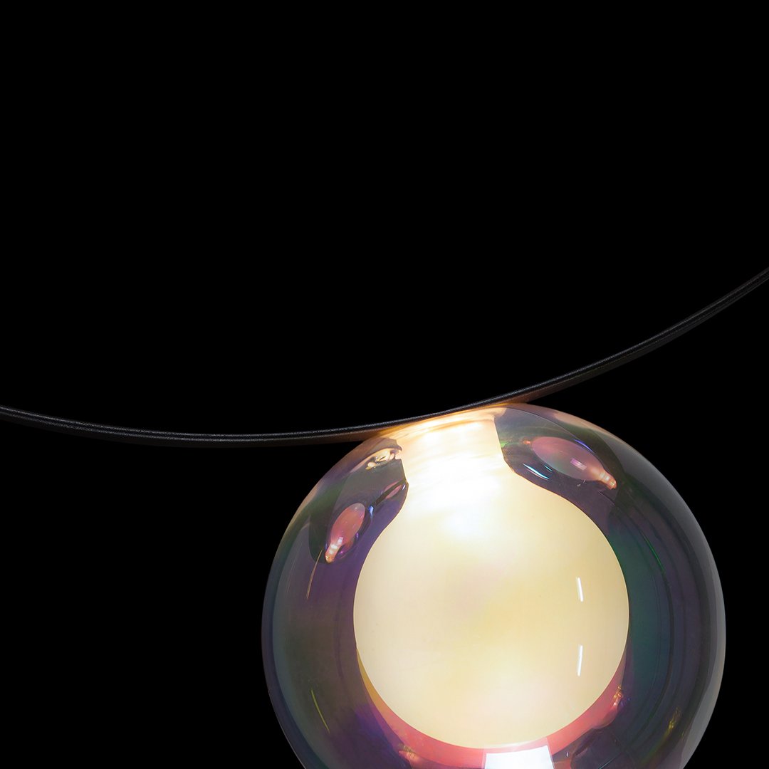 Iridescent bubble pendant on black background, featuring soft pastel hues and vibrant colorful reflections.