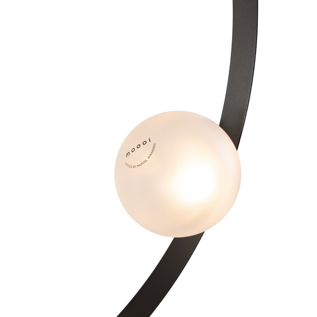 Modern lamp featuring a sleek black arc and a smooth, glowing white orb. Stylish and contemporary design.