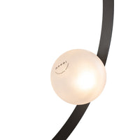 Modern lamp featuring a sleek black arc and a smooth, glowing white orb. Stylish and contemporary design.