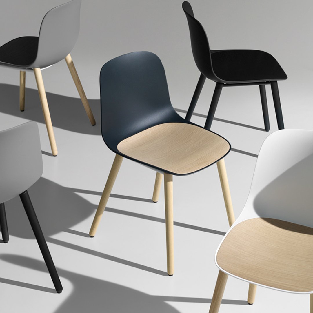 Colorful modern chairs featuring gray, black, navy, and white with natural wood seats. Stylish minimalist design patterns.