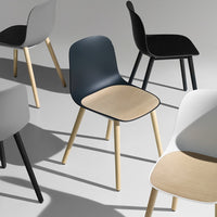 Colorful modern chairs featuring gray, black, navy, and white with natural wood seats. Stylish minimalist design patterns.