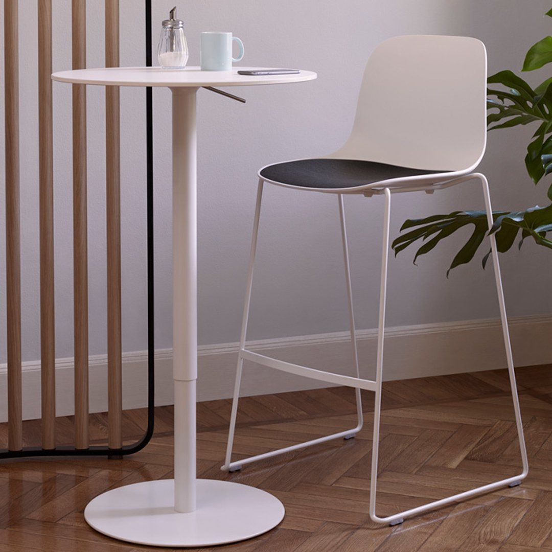 Modern white bar table with sleek black and white chair, featuring minimalist design and smooth surfaces.
