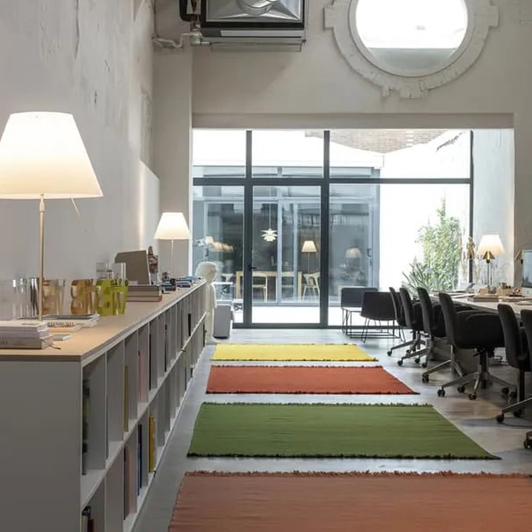 Colorful area rugs in orange, green, and light hues, enhancing a modern workspace ambiance.
