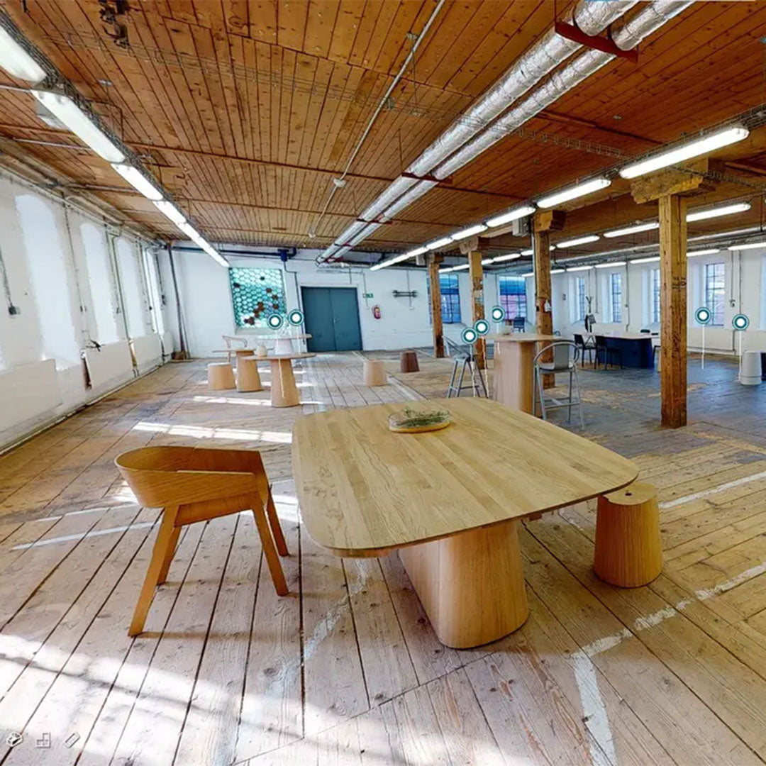 Light wood textures on furniture, with warm wooden tones contrasted by an industrial setting and subtle blue accents.