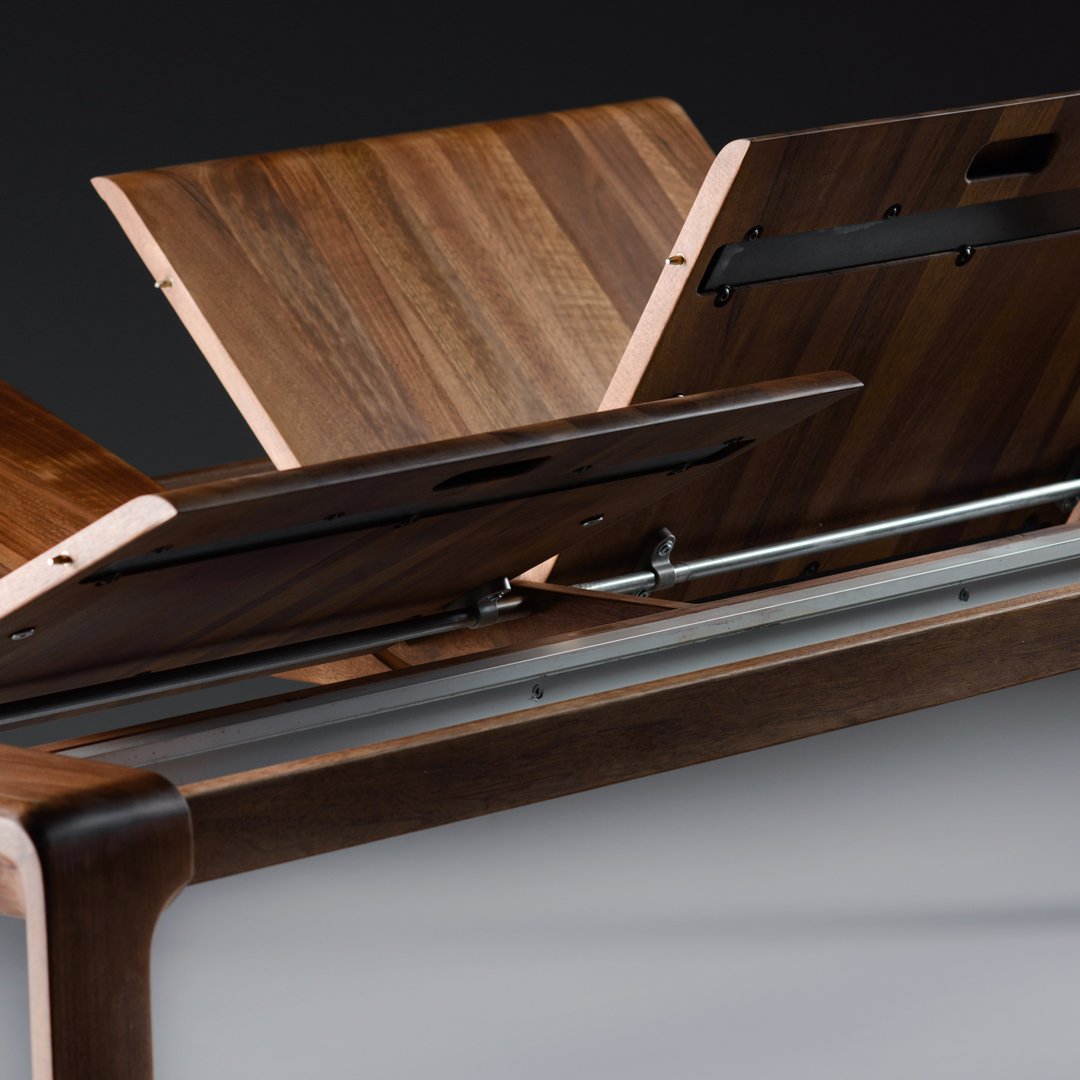 Wooden table with rich walnut finish, showcasing sleek, modern design and subtle grain patterns.