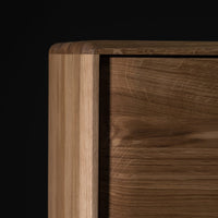 Close-up of smooth, warm wooden texture with light and dark brown tones against a black background.