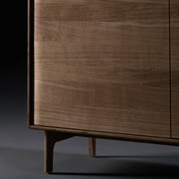 Wooden cabinet with a rich walnut finish and smooth, natural grain patterns. Stylish tapered legs add elegance.
