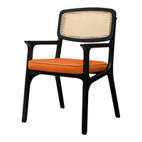 Black wooden chair with a woven rattan back and vibrant orange cushion featuring yellow trim. Stylish and modern design.