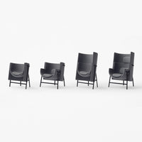 Set of four modern armchairs in sleek black with smooth curved lines and minimalist design. Perfect for contemporary decor.