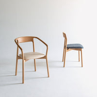 Two stylish chairs in natural wood tones, featuring a beige seat and a blue upholstered back. Elegant and modern design.