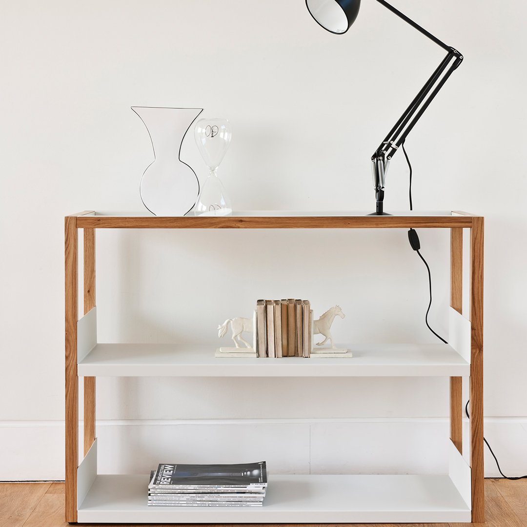 "Modern wooden console table with white shelves and natural wood accents, featuring a sleek black lamp."