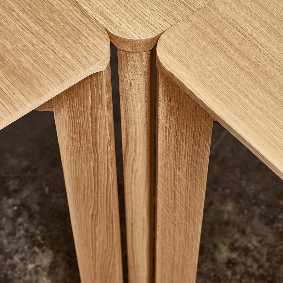 Light oak wood table corners with textured grain pattern and smooth finish, showcasing neutral tones.