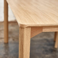 Natural light oak wood table with subtle grain patterns and smooth, rounded edges. Earthy tones for a warm aesthetic.