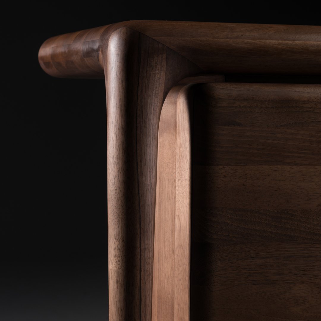 Close-up of a rich walnut wood surface showcasing smooth, natural grain and warm brown tones.