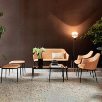 Modern living room set featuring peach upholstery with black accents on furniture against a warm, earthy background.