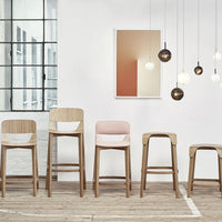 "Modern wooden bar stools in natural wood, soft pink, and white, set against a neutral backdrop with pendant lights."