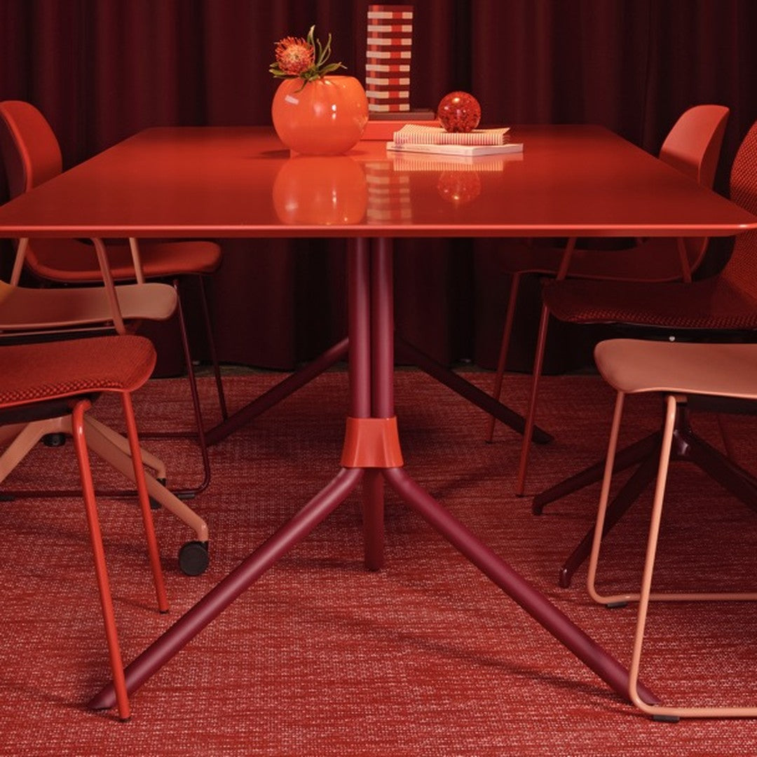 Red dining table with matching chairs and decor; features rich textures and warm hues in a coordinated color palette.