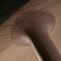 Close-up of a light wood grain finish with a smooth, round base in contrasting darker tones.