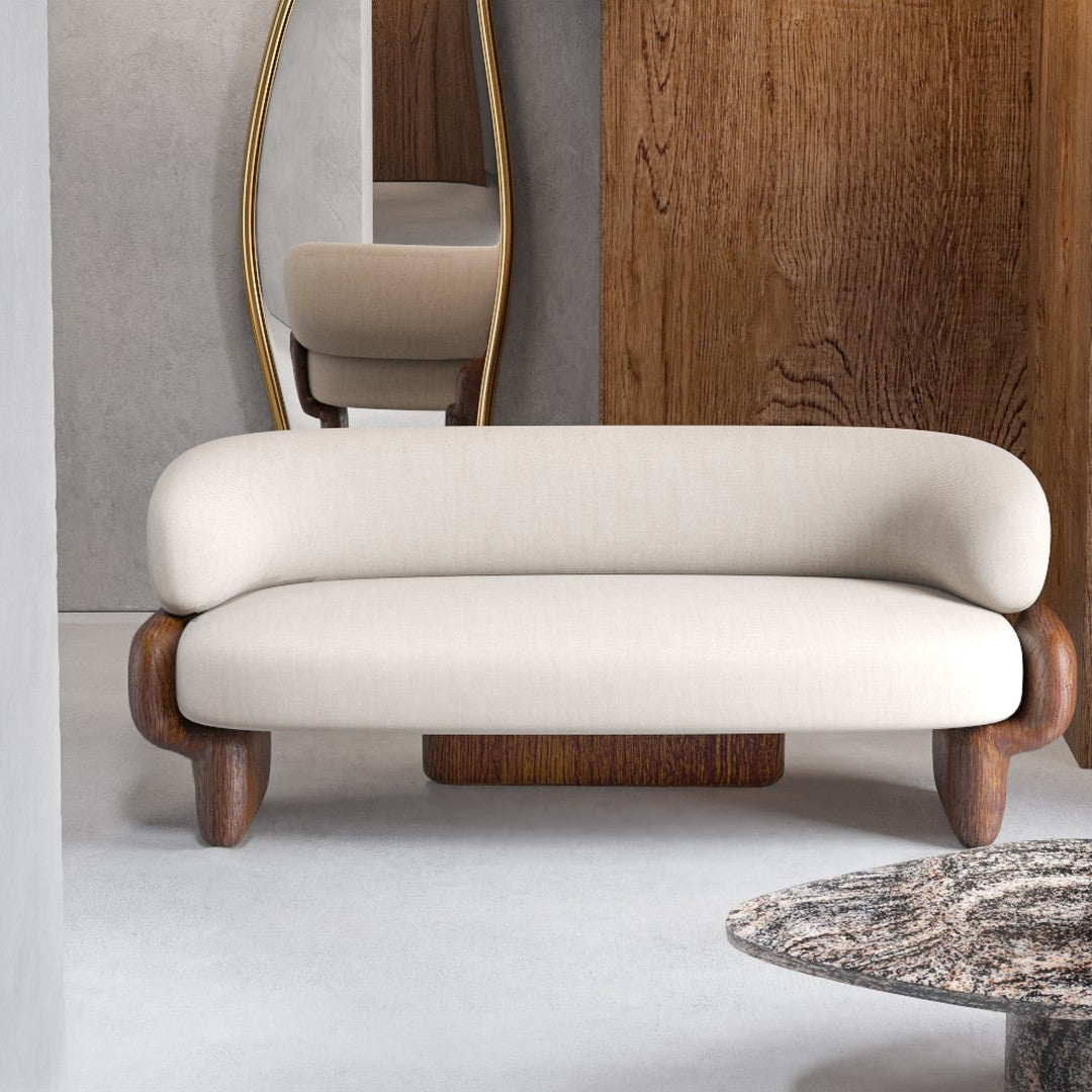 Beige upholstered sofa with curved design and wooden legs, set against neutral-colored modern decor.