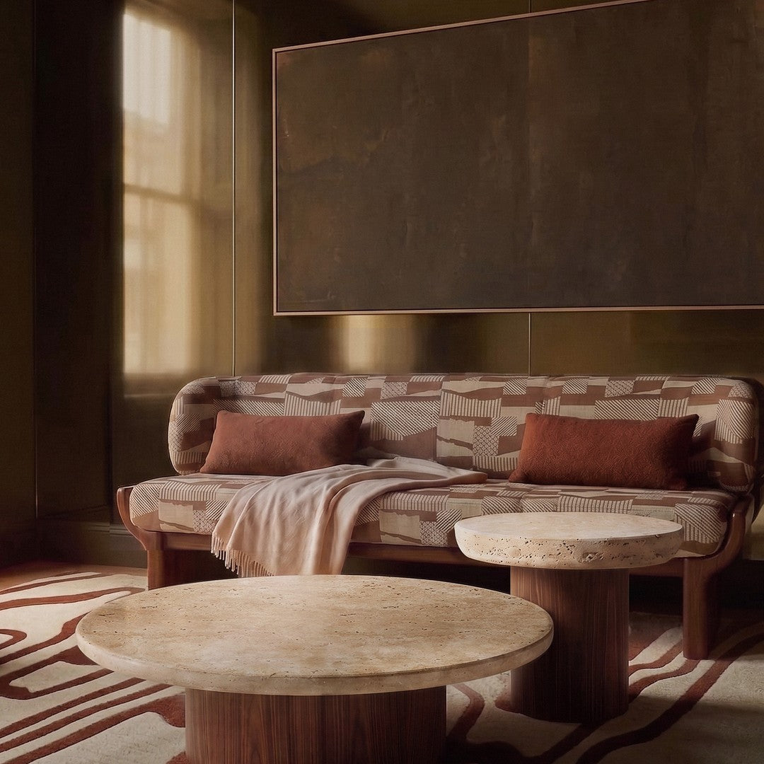 Earthy tones with geometric patterns on a cozy sofa and two round tables, set in a warm, inviting interior.