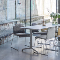 Modern dining set featuring gray and beige chairs with textured patterns against a minimalist backdrop.