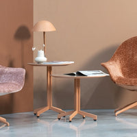"Soft peach and beige tones with textured patterns on accent furniture and a minimalist lamp in a modern living space."