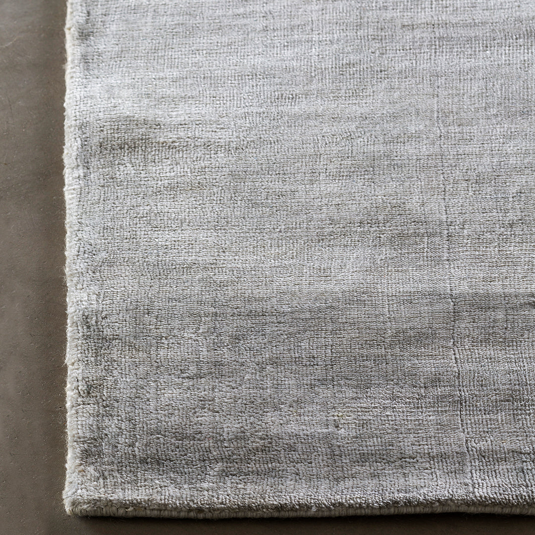Soft gray area rug with a subtle, textured pattern, featuring a gradient effect for a modern touch.
