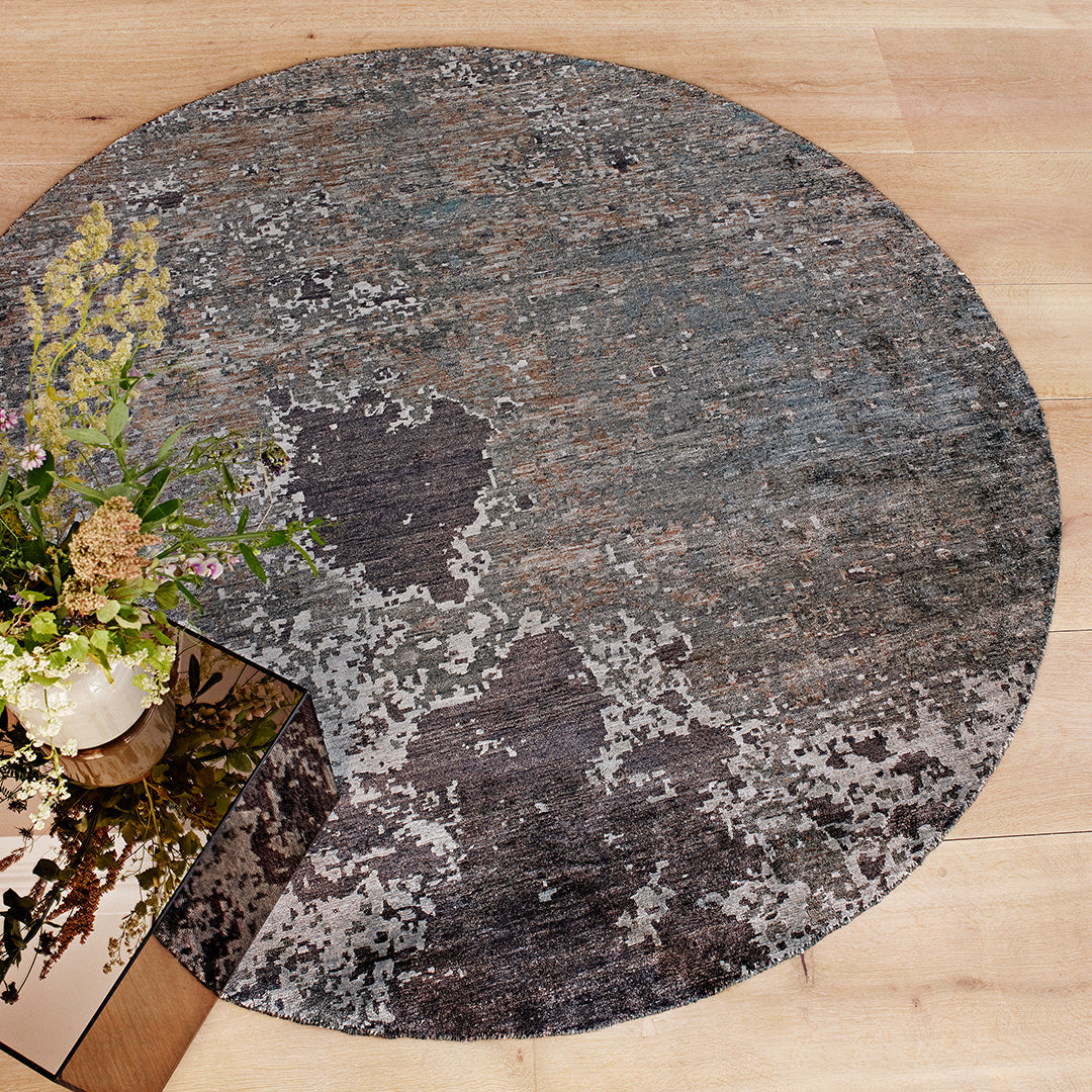 Round rug featuring a textured blend of gray, blue, and subtle patterns for a modern, stylish look.