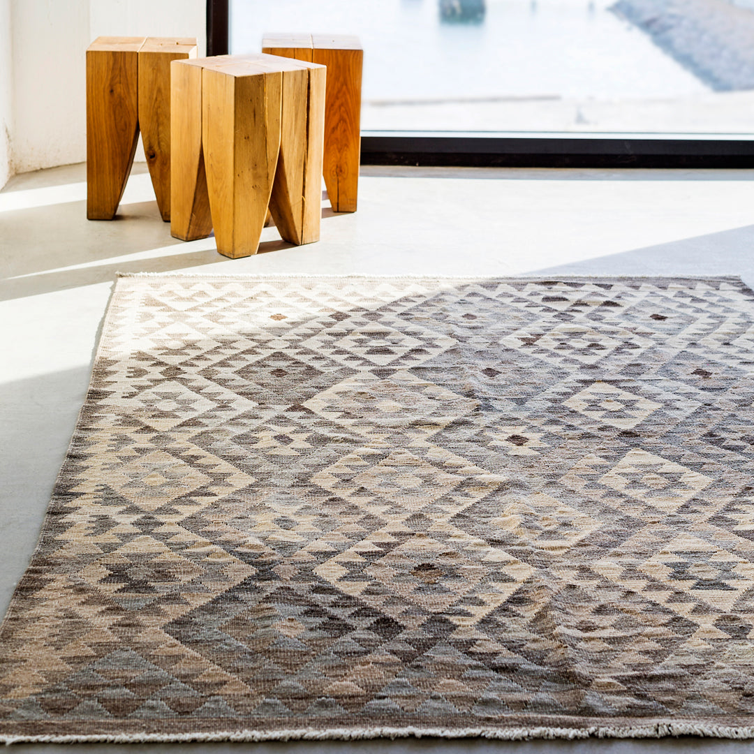 Beige and brown geometric patterned rug with diamond motifs and soft textures. Ideal for modern decor.