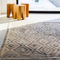 Beige and brown geometric patterned rug with diamond motifs and soft textures. Ideal for modern decor.