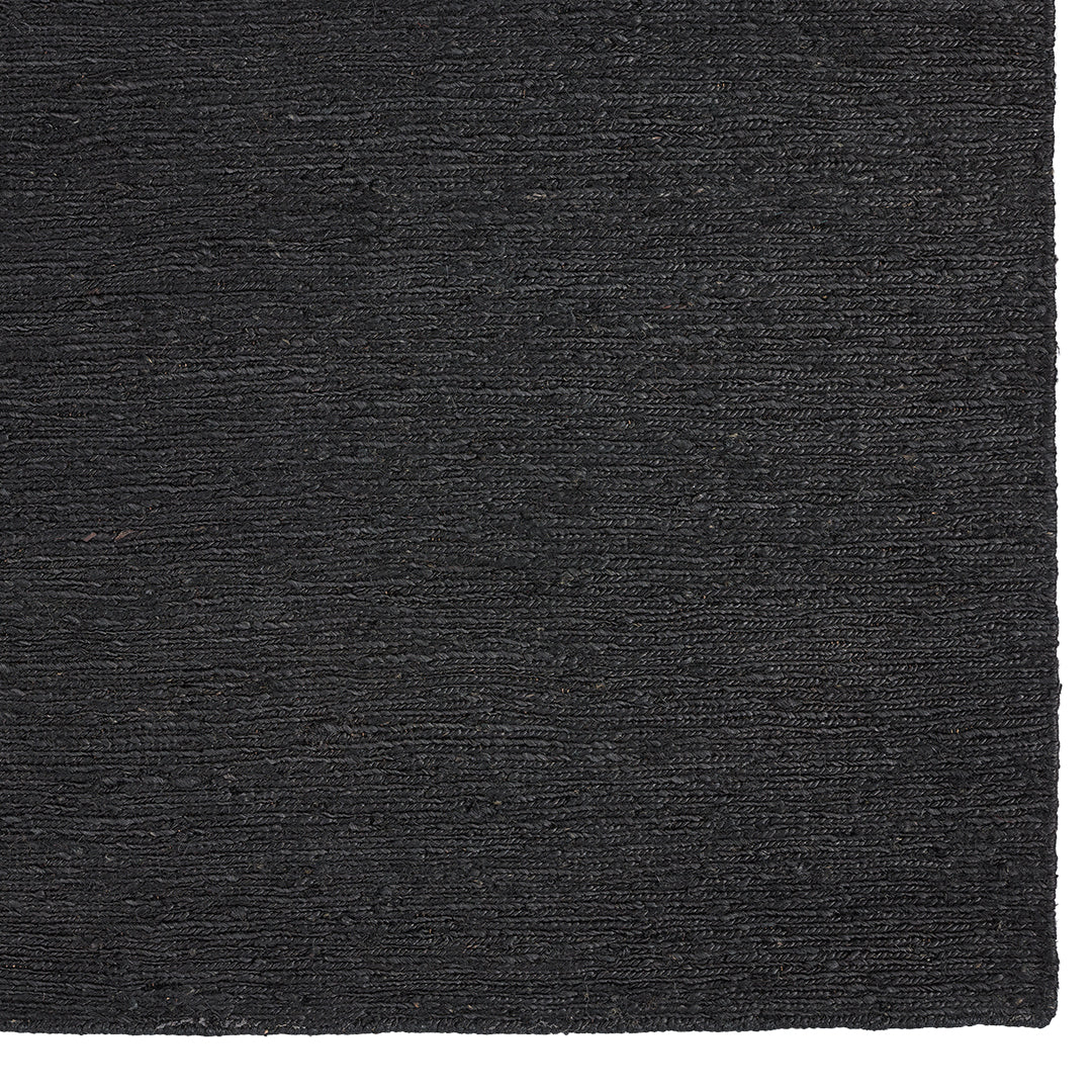 Black textured rug with a subtle woven pattern, perfect for modern decor.