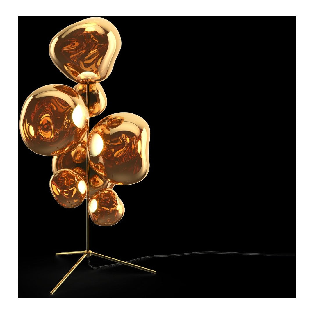 Gold sculptural floor lamp with smooth, organic shapes on a sleek black background. Modern and eye-catching design.