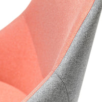 "Close-up of a chair featuring vibrant coral and sleek gray fabric with a smooth, modern texture."