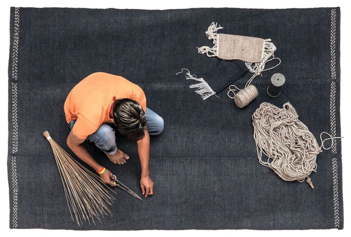 "Handcrafted rug featuring dark blue base with intricate white patterns, ideal for adding depth to any space."