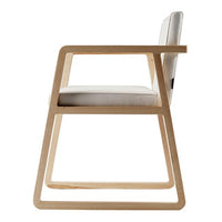 Minimalist wooden chair with a natural finish and a white cushion, showcasing a contemporary design.