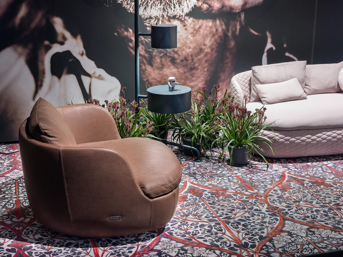 Brown bean bag chair on a vibrant patterned rug, featuring intricate florals and in rich colors, with a cozy ambiance.