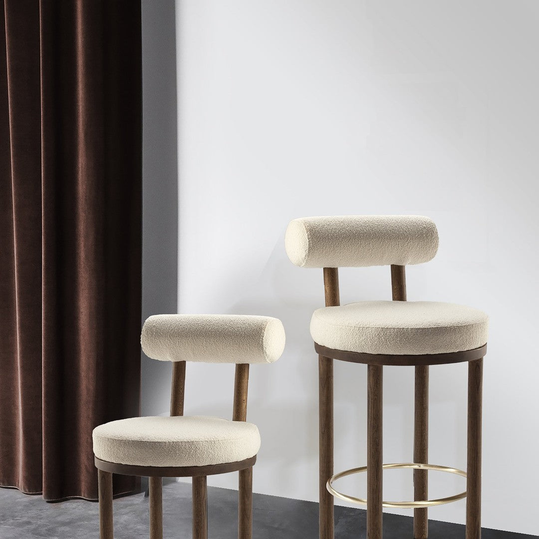 Beige upholstered bar stools with rounded backs, complemented by a rich brown velvet curtain backdrop.