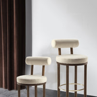 Beige upholstered bar stools with rounded backs, complemented by a rich brown velvet curtain backdrop.