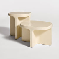 Beige sculptural side tables with smooth, rounded edges and a modern minimalist design. Perfect for stylish decor.