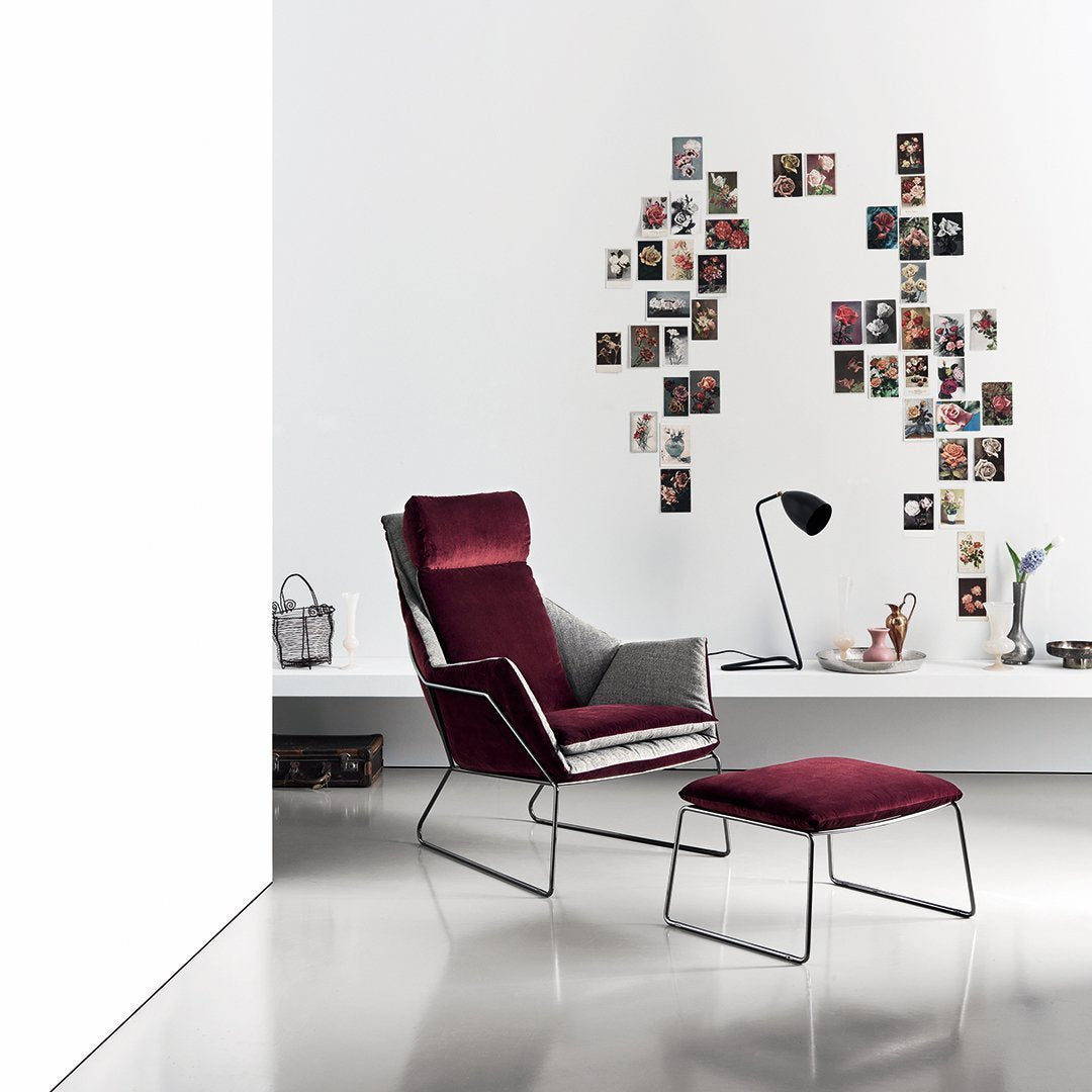 Modern armchair in burgundy and gray fabric with minimalist steel frame, complemented by a matching footrest.